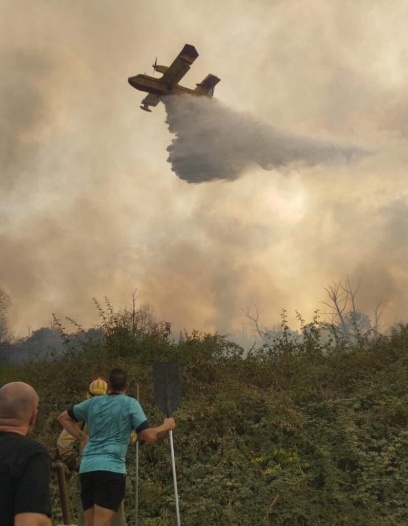 Un avión descarga agua sobre el incendio de Molinaseca. EV.